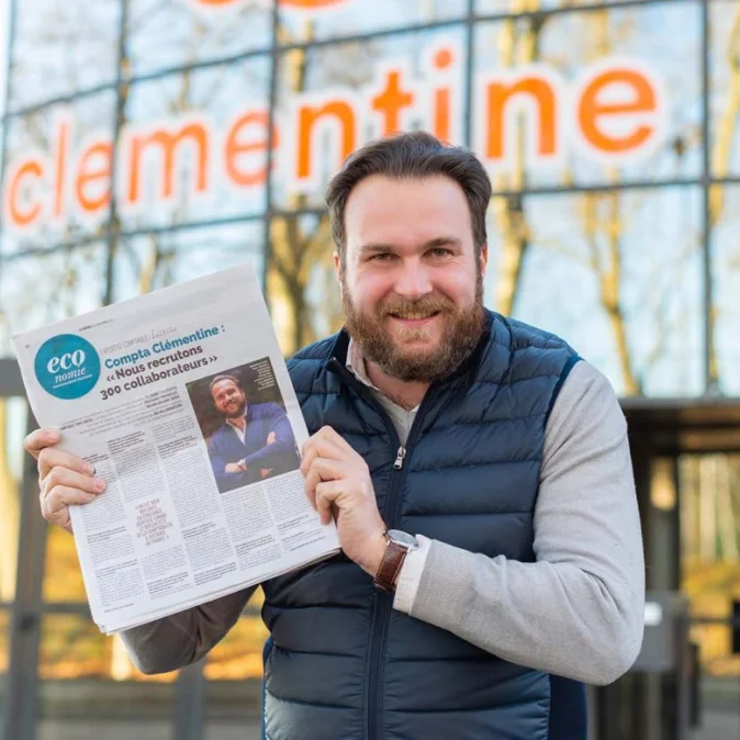 Photo de Maximilien, qui tient un journal Économie avec un article sur Clementine